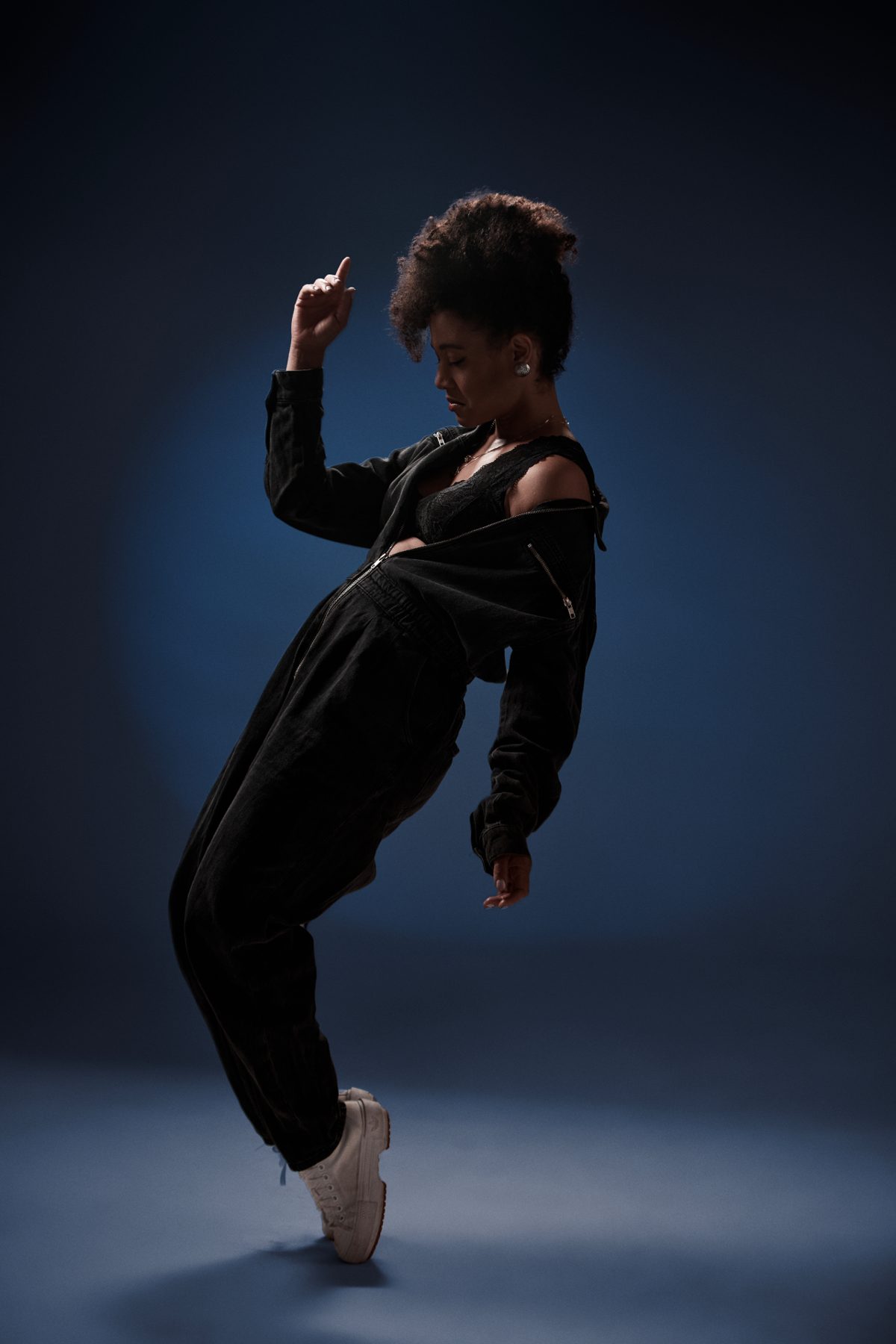 Arlene Gould dancing in a dark studio, lit in deep blue